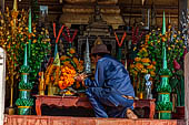 Vientiane, Laos - Pha That Luang, worshipper placing offers to the temple. 